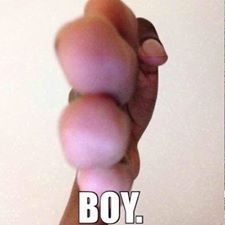 a hand holding a pink object with the words boy on it in front of white background