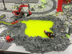 a lego model is shown with construction equipment on the ground and in front of it