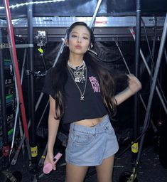 a woman standing in front of a rack with skis on her shoulders and headphones to her ear