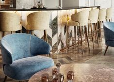 a bar with blue velvet chairs and marble counter tops, in front of an abstract wallpaper