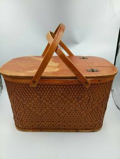 a basket with two wooden handles sitting on a white surface