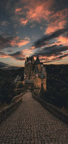 an image of a castle that is in the sky with clouds above it and cobblestone walkway leading up to it