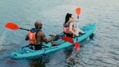 two people in a kayak paddling on the water with paddles and oars