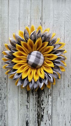 a sunflower is hanging on the side of a white fence with grey and yellow accents