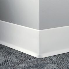 the corner of an empty room with carpeting on the floor and white walls in the background