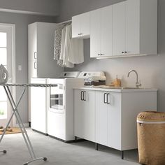 a laundry room with white cabinets and appliances