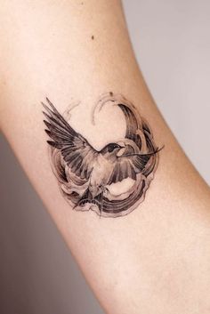 a small bird tattoo on the arm