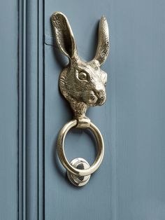 a metal door handle with a rabbit head on it's side and a ring at the end