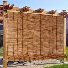 a wooden bench sitting in front of a bamboo fence