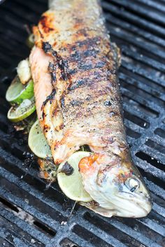 grilled fish on the grill with sliced cucumbers