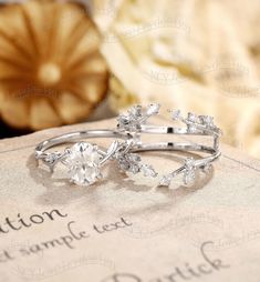 two wedding rings sitting on top of an old book