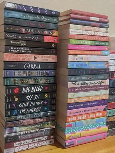 a stack of books sitting on top of a wooden table next to each other in front of a wall