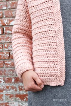 a person wearing a pink crochet sweater