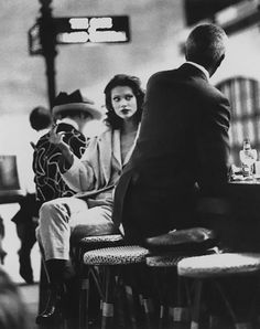 a man and woman sitting on stools at a bar