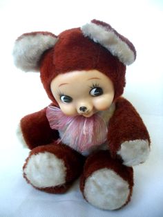 a small teddy bear with a pink bow on its neck and ears, wearing a red hat