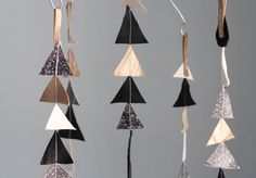 a group of hanging ornaments made out of wood and metal strips on a gray background