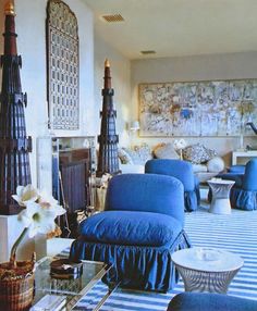 an image of a living room setting with blue furniture and decor on the walls,