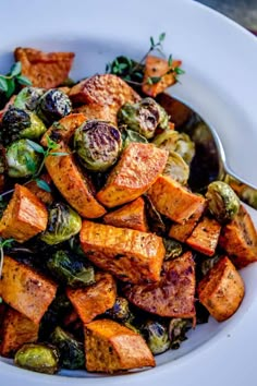 a white plate topped with sweet potatoes and brussel sprouts