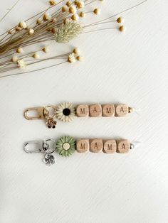 three wooden key chains with the word mama written on them next to some dried flowers