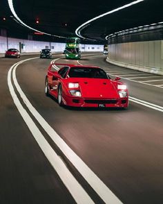 a red sports car driving down a highway at night with other cars in the background