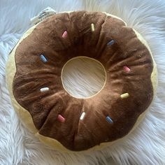 a donut shaped pillow sitting on top of a white blanket