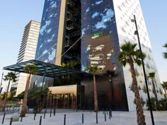 a tall building with palm trees in front of it