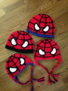 three crocheted spiderman hats are laying on the floor