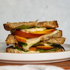 a white plate topped with a cut in half sandwich