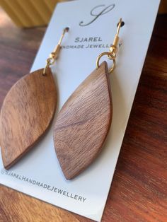 the wooden earrings are on top of a card