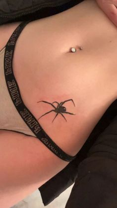 a woman with a spider tattoo on her stomach