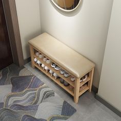 a wooden bench sitting next to a wall with a round mirror on it's side