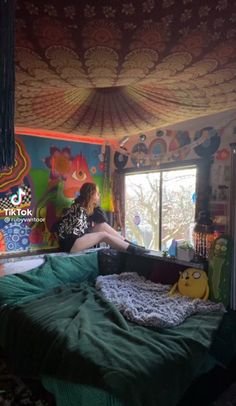 a woman sitting on top of a bed in a room with colorful walls and ceiling