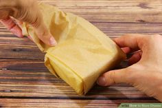 two hands reaching for a piece of food on a wooden table