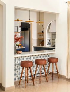 three stools sit in front of a kitchen island with two bar stools next to it