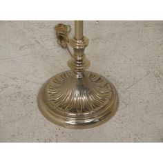 a brass table lamp sitting on top of a marble floor