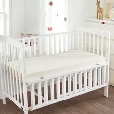 a white crib in the corner of a room