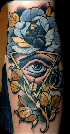 an illuminate tattoo on the leg of a person's leg with flowers and an all seeing eye