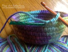 a crochet basket with yarn and a knitting needle