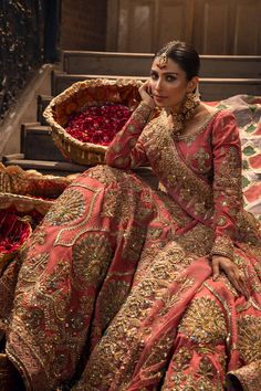 a woman in a red and gold dress sitting on steps next to a basket filled with roses