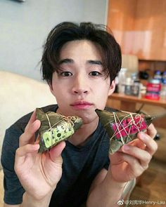 a young man holding up two pieces of food