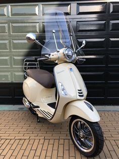 a white scooter parked in front of a garage door