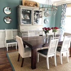 a dining room table with white chairs and blue walls