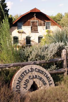 an old wheel sits in front of a building with a sign on it that says,