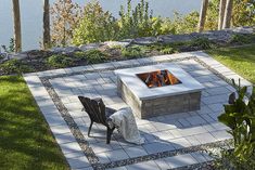 a fire pit sitting on top of a lush green field