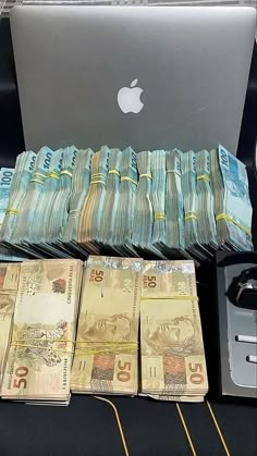 stacks of money sitting in front of an apple computer