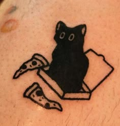 a black cat sitting on top of a piece of pizza next to a slice of pizza