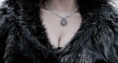 a close up of a woman wearing a fur coat with a necklace on her neck