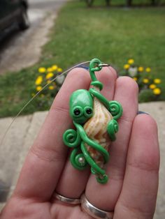 an octopus is sitting on top of a shell in the palm of someone's hand