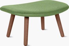 an upholstered stool with wooden legs and a green seat cover on the top