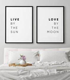 two black and white posters on the wall above a bed